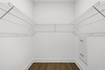 A white room with a wood floor and empty shelves.